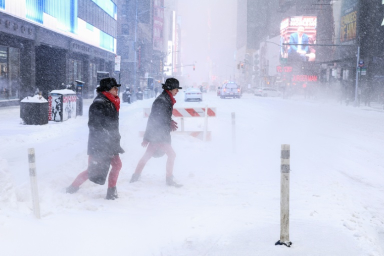 Des passants sur la 6e avenue en pleine tempête de neige à New York le 25 janvier 2026 ( AFP / CHARLY TRIBALLEAU )