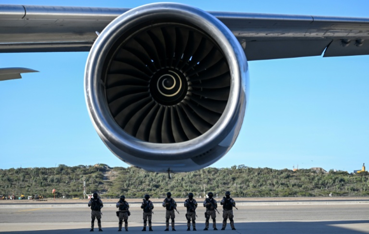 Des policiers sur le tarmac de l'aéroport international de Caracas, pendant l'arrivée d'un vol d'Eastern Airlines rapatriant des migrants depuis les Etats-Unis, le 3 décembre 2025 ( AFP / Juan BARRETO )