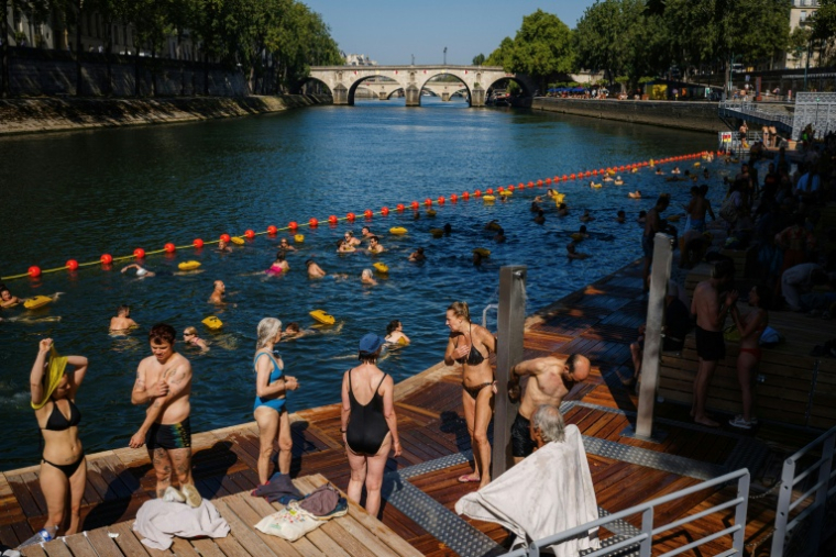 Des baigneurs dans la Seine à Paris le 12 août 2025 ( AFP / Dimitar DILKOFF )