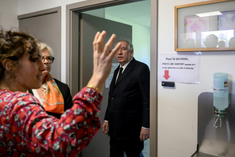 Le Premier ministre François Bayrou (c) rencontre des professionnels de la santé lors de sa visite du centre de santé Calvinet sur le thème des déserts médicaux à Puycapel, le 25 avril 2025 dans le Cantal ( AFP / Ed JONES )