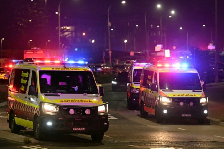 Des ambulances à proximité de la célèbre plage de Bondi à Sydney, théâtre d'une attaque par balles qui a fait onze  morts, le 14 décembre 2025 ( AFP / Saeed KHAN )