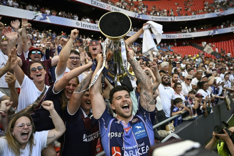 Matthieu Jalibert de Bordeaux-Bègles brandit la Champions Cup remportée pour la deuxième année consécutive, le 23 mai 2026 à Bilbao face au Leinster ( AFP / ANDER GILLENEA )