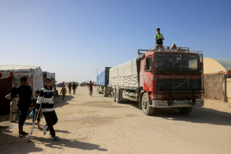 Des Palestiniens regardent des camions transportant de l'aide humanitaire arriver à Khan Younès, dans le sud de la bande de Gaza, après avoir franchi le poste-frontière de Rafah depuis l'Egypte, le 1er février 2026 ( AFP / Bashar Taleb )