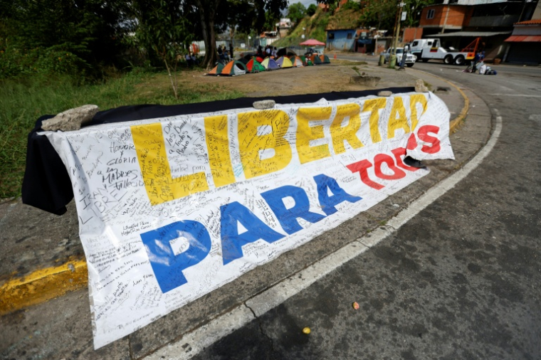 Une banderole "Liberté pour tous" déployée devant la prison Rodeo I à Guatire, dans l'État de Miranda, au Venezuela, le 20 février 2026 ( AFP / Pedro MATTEY )