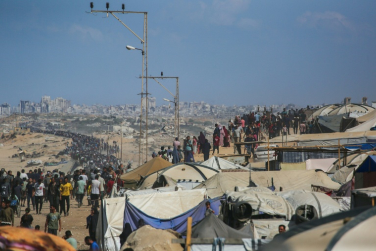 Des Palestiniens marchent sur la route al-Rachid en direction de la ville de Gaza, depuis Nousseirat, dans le centre de la bande de Gaza, le 10 octobre 2025 ( AFP / Bashar TALEB )