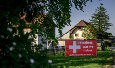 Une banderole électorale en faveur d'une initiative visant à plafonner la population à 10 millions d'habitants, affichée en bord de route avec l'inscription en allemand "Préservons ce que nous aimons", près de Morat, le 26 mai 2026 en Suisse ( AFP / Fabrice COFFRINI )