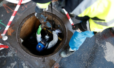 Photo d'un ouvrier qui sort d'un tuyau d'égout après une intervention dans les égouts de Paris