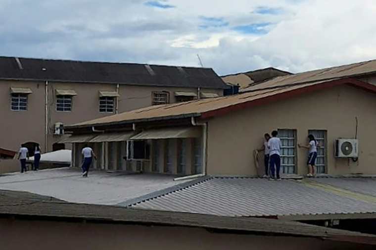 Des élèves de l'Institut Sao José sont réfugiés sur le toit alors qu'un adolescent a ouvert le feu dans l'établissement, à Rio Branco, dans l'Etat amazonien d'Acre, au Brésil, le 5 mai 2026 ( AFP / STRINGER )