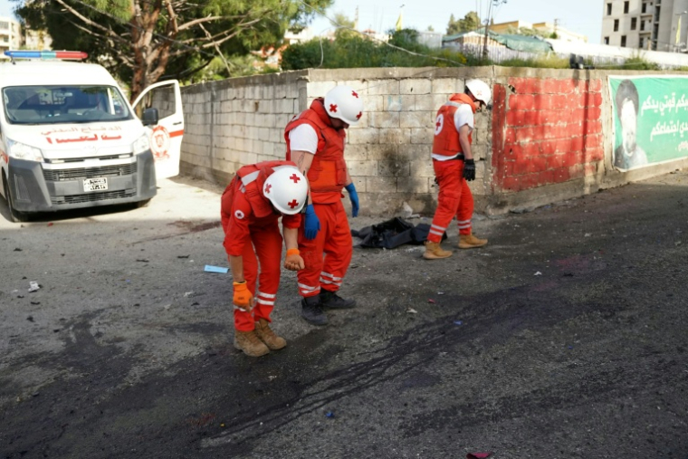 Des membres de la Croix-Rouge libanaise inspectent le site d'une frappe israélienne qui a ciblé des secouristes en intervention à Nabatiyé, dans le sud du Liban, le 12 mai 2026 ( AFP / Abbas Fakih )