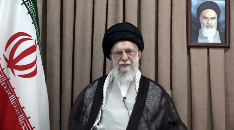 Une photo fournie par le bureau du guide suprême iranien, Ali Khamenei, le montre, flanqué du drapeau iranien et d'un portrait du défunt leader de la révolution islamique, l'imam Khomeini, et prononçant un discours télévisé, le 18 juin 2025 ( KHAMENEI.IR / - )