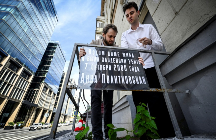 Des membres du parti d'opposition russe Iabloko installent une plaque commémorative à l'entrée de l'immeuble où vivait la journaliste assassinée Anna Politkovskaïa, à Moscou, le 14 juillet 2026 ( AFP / Alexander NEMENOV )