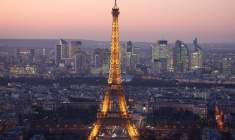 Une vue générale montre la Tour Eiffel illuminée et la ligne d'horizon du quartier d'affaires de La Défense de nuit à Paris