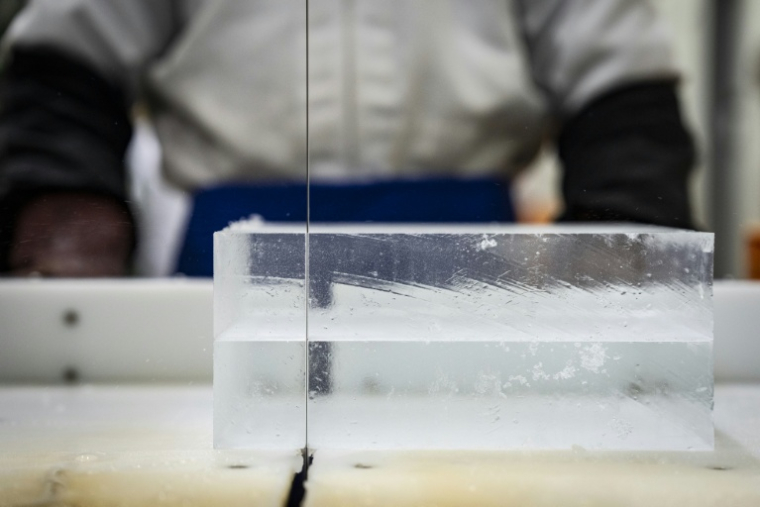 Un employé découpe de la glace à l'usine Kuramoto Ice à Kanazawa, au Japon, le 15 juin 2026 ( AFP / Yuichi YAMAZAKI )