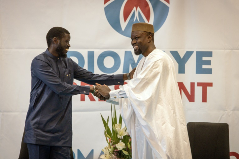 Ousmane Sonko (d), libéré de prison la veille, salue Bassirou Diomaye Faye, lors d'une conférence de presse à Dakar le 15 mars 2024 ( AFP / JOHN WESSELS )