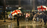 Des manifestants face à la police anti-émeute lors d'un rassemblement de l'opposition le jour des élections locales, le 4 octobre 2025 à Tbilissi, en Géorgie ( AFP / GIORGI ARJEVANIDZE )