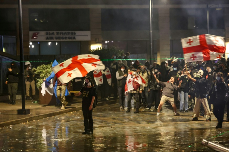 Des manifestants face à la police anti-émeute lors d'un rassemblement de l'opposition le jour des élections locales, le 4 octobre 2025 à Tbilissi, en Géorgie ( AFP / GIORGI ARJEVANIDZE )