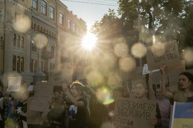 Des manifestants brandissent des pancartes lors d'une manifestation contre une loi qui supprime l'indépendance d'organismes anticorruption dans le centre-ville de Kiev, le 23 juillet 2025 ( AFP / Roman PILIPEY )