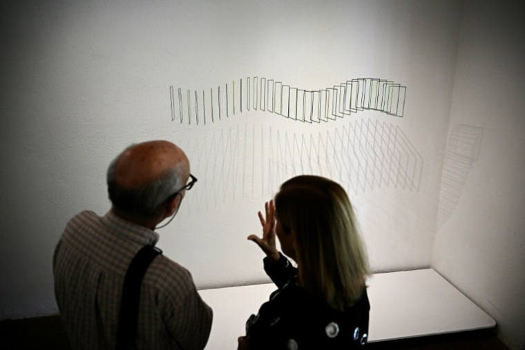 Des visiteurs devant une oeuvre de l'artiste vénézuélien Elias Crespin lors de son exposition "Continuum" à la galerie d'art Hacienda La Trinidad à Caracas, le 28 mai 2025 au Venezuela ( AFP / Federico PARRA )