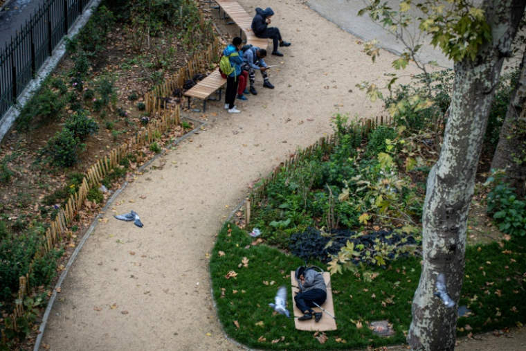 Une personne SDF dort dans un parc, le 1er octobre 2019, place de La Chapelle à Paris ( AFP / JOEL SAGET )