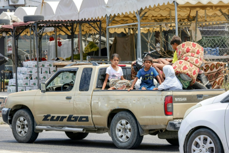 Des enfants assis à l'arrière d'une camionnette, alors que les habitants fuient la ville de Tyr, au sud du Liban, après un ordre d'évacuation lancé par Israël, le 9 juin 2026 ( AFP / MAHMOUD ZAYYAT )