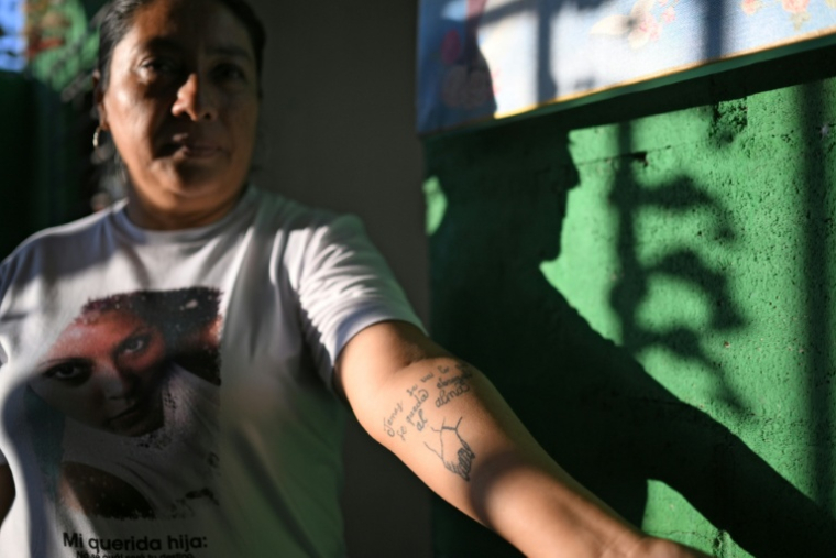 Tomasa Lopez montre un tatouage sur son bras dédié à sa fille Kathya, disparue en 2016, à Mejicanos, le 20 mars 2026 au Salvador ( AFP / STRINGER )