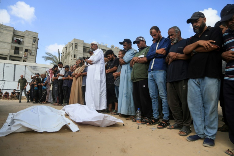 Des Palestiniens récitent une prière à côté de corps de personnes tuées près d'un centre d'aide humanitaire dans la région d'Al-Tina, à Khan Younès, dans le sud de la bande de Gaza, à l’hôpital Nasser, le 19 juillet 2025 ( AFP / - )