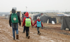 Des Syriens déplacés près de tentes dans un camp à Azaz