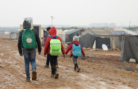 Des Syriens déplacés près de tentes dans un camp à Azaz