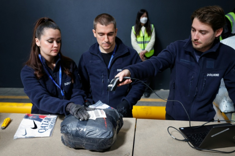 Des agents des douanes inspectent des colis de fret aérien dans un entrepôt de l’aéroport de Roissy-Charles de Gaulle, près de Paris, le 29 avril 2025 ( AFP / GEOFFROY VAN DER HASSELT )