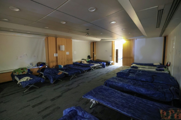 Une personne se repose sur un lit de camp dans un centre d'hébergement d'urgence pendant la vague de chaleur à Paris, le 26 juin 2026 ( AFP / Ludovic MARIN )