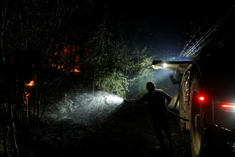Un agriculteur arrose la forêt de Fontainebleau, après qu'un incendie de forêt s'est déclaré en fin d'après-midi à Noisy-sur-École, le 12 juillet 2026 ( AFP / GEOFFROY VAN DER HASSELT )