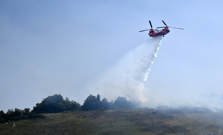 Un hélicoptère bombardier d'eau largue une cargaison d'eau sur un feu de forêt près d'Etsaut, dans les Pyrénées-Atlantiques, le 6 septembre 2026 ( AFP / Gaizka IROZ )