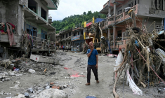 Un habitant passe devant des maisons endommagées par des crues soudaines à Devighat, dans le district de Nuwakot, le 31 août 2026 au Népal ( AFP / Arun SANKAR )