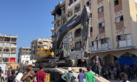 Des Gazaouis observent des véhicules de construction déployés au nord de Khan Younès
