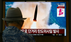 Des images d'archives d'un tir de missile nord-coréen diffusées lors d'un reportage sur un écran dans une gare de Séoul, le 6 août 2026 ( AFP / GREG BAKER )