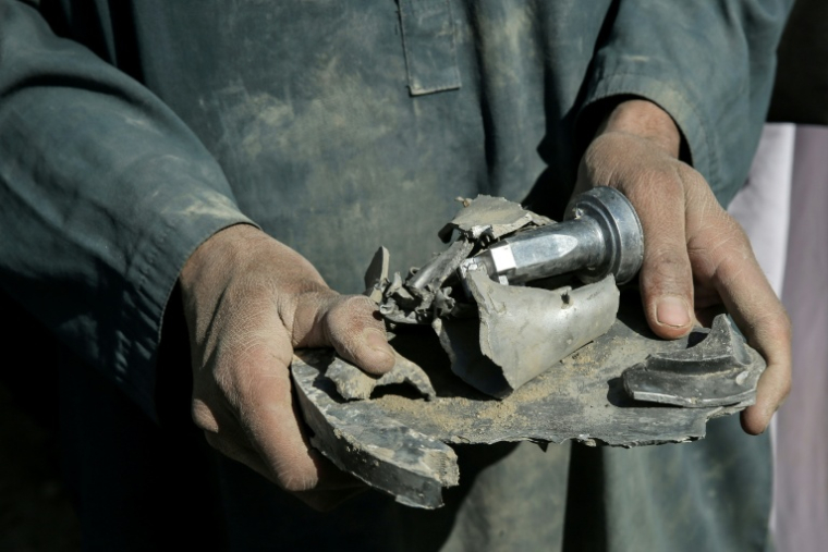 Un Afghan tient un fragment d'obus de mortier après des frappes aériennes du Pakistan à la frontière de l'Afghanistan, le 22 février 2026 dans la province de Nangarhar, dans l'est de l'Afghanistan  ( AFP / - )