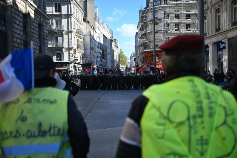 Des manifestants portant des gilets jaunes font face à des gendarmes place de la République à Paris le 17 octobre 2026  ( AFP / Matthieu RONDEL )