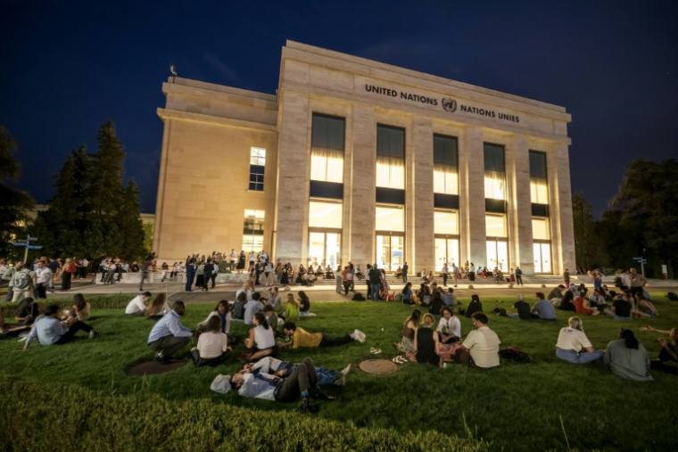Dans l'attente d'une réunion plénière qui n'arrivait pas, les délégués, membres de la société civile, sont sortis devant le palais des Nations pour attendre le résultat des négociations menées à l'intérieur, le 14 aout 2025 ( AFP / Fabrice COFFRINI )