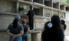 Le frère d'un homme, mort aux côtés de son épouse et de deux enfants lors du double séisme à La Guaira, dispose des fleurs dans la niche funéraire dans un cimetière de Caracas, le 29 juin 2026 ( AFP / Rosali Hernandez )