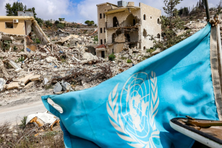 Un drapeau de l'ONU flotte sur un véhicule blindé de la Force intérimaire des Nations unies au Liban (Finul), en patrouille près de bâtiments détruits dans le village de Kfar Kila (sud du Liban), près de la frontière avec le nord d'Israël, le 27 août 2025 ( AFP / ANWAR AMRO )