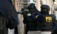 Des policiers pénètrent dans une habitation lors d'une opération antidrogue   à Santiago, le 11 décembre 2025  ( AFP / Rodrigo ARANGUA )