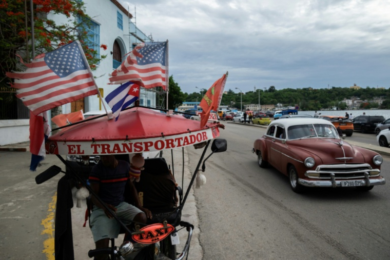 Un tricyle-taxi orné de drapeaux américains, dans une rue de La Havane, le 19 juin 2026 à Cuba ( AFP / YAMIL LAGE )