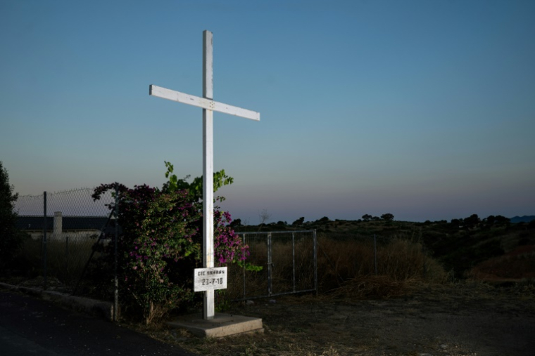 Photo prise le 24 juin 2026 d'une croix érigée dans le village de Mati, dans la banlieue d’Athènes, près de l’endroit où quatre personnes ont été retrouvées mortes à la suite de l'incendie de forêt de 2018 ( AFP / Angelos TZORTZINIS )