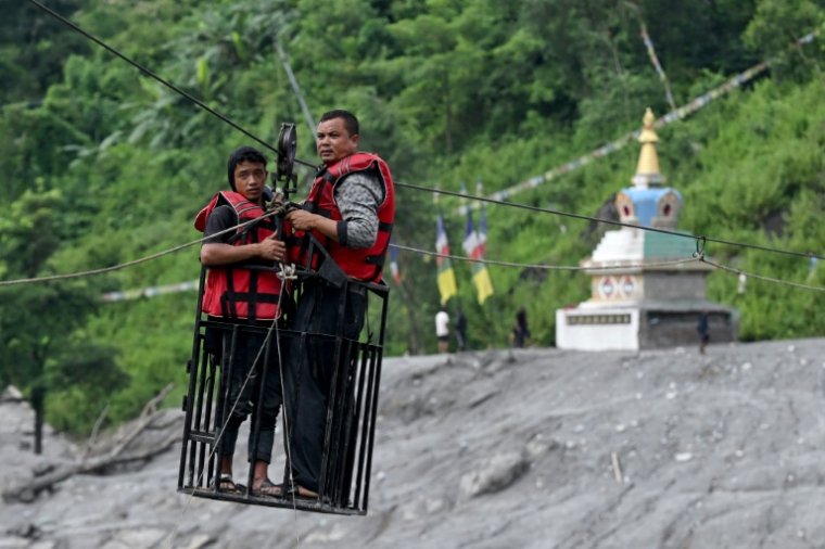 Des habitants traversent la rivière Trishuli avec une tyrolienne récemment installée à Bidur, au Népal, le 2 septembre 2026 ( AFP / Arun SANKAR )
