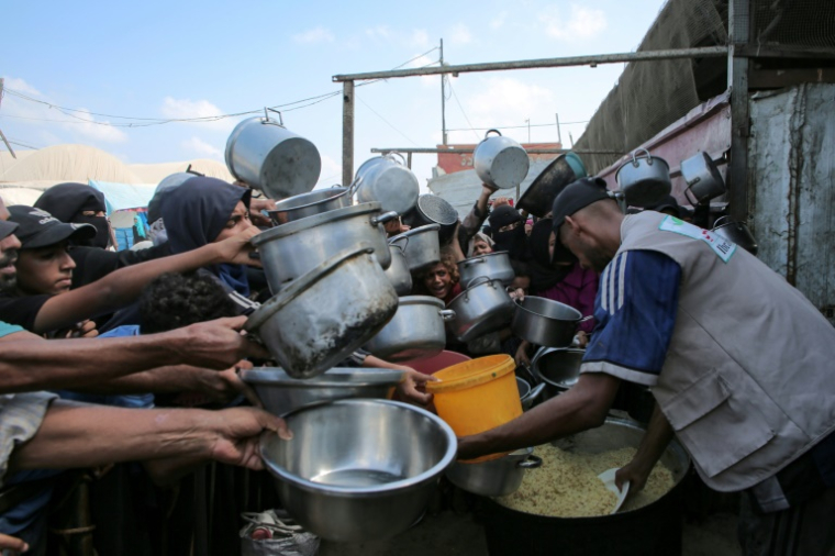 Des Palestiniens attendent une distribution de repas à Khan Younès, dans le sud de la bande de Gaza, le 21 août 2025 ( AFP / - )
