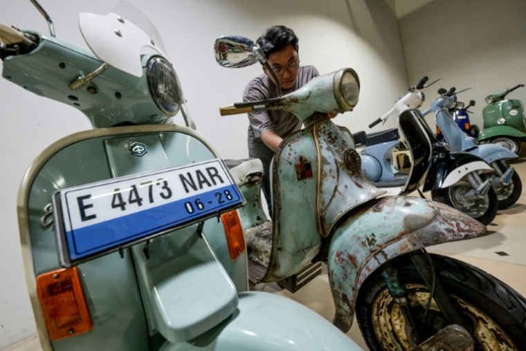 Un employé d'un atelier inspecte une Vespa qui a été convertie à l'électrique le 3 mars 2025 à Jakarta ( AFP / BAY ISMOYO )