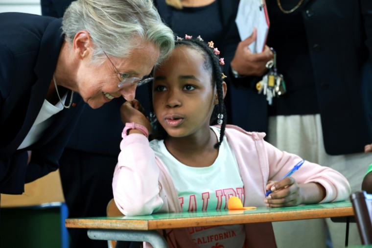 La ministre de l'Education Elisabeth Borne, discute avec une élève à l'occasion de la rentrée scolaire dans le quartier de Primat, à Saint-Denis de la Réunion, sur l'île de La Réunion, le 19 août 2025 ( AFP / Richard BOUHET )