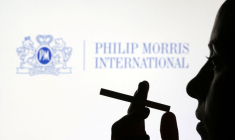 Une femme avec une cigarette devant le logo de Philip Morris International
