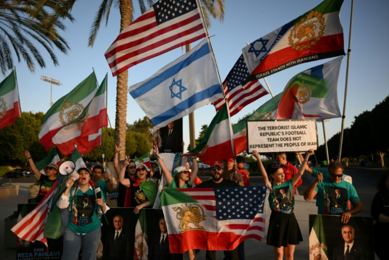 Des manifestants agitent des drapeaux de l'Iran pré-révolutionnaire à l'extérieur du stade où s'entraîne la sélection iranienne, le 14 juin 2026 à Los Angeles, à la veille de son entrée en lice dans le Mondial contre la Nouvelle-Zélande ( AFP / Patrick T. Fallon )