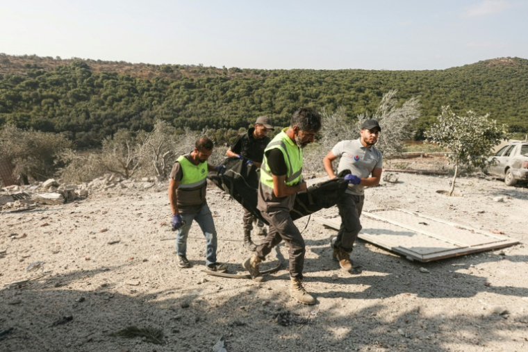Les premiers secours évacuent un corps des décombres à la suite d'une frappe aérienne israélienne qui a visé une maison dans le village d'Ansar, dans le sud du Liban, le 15 août 2026.  ( AFP / MAHMOUD ZAYYAT )